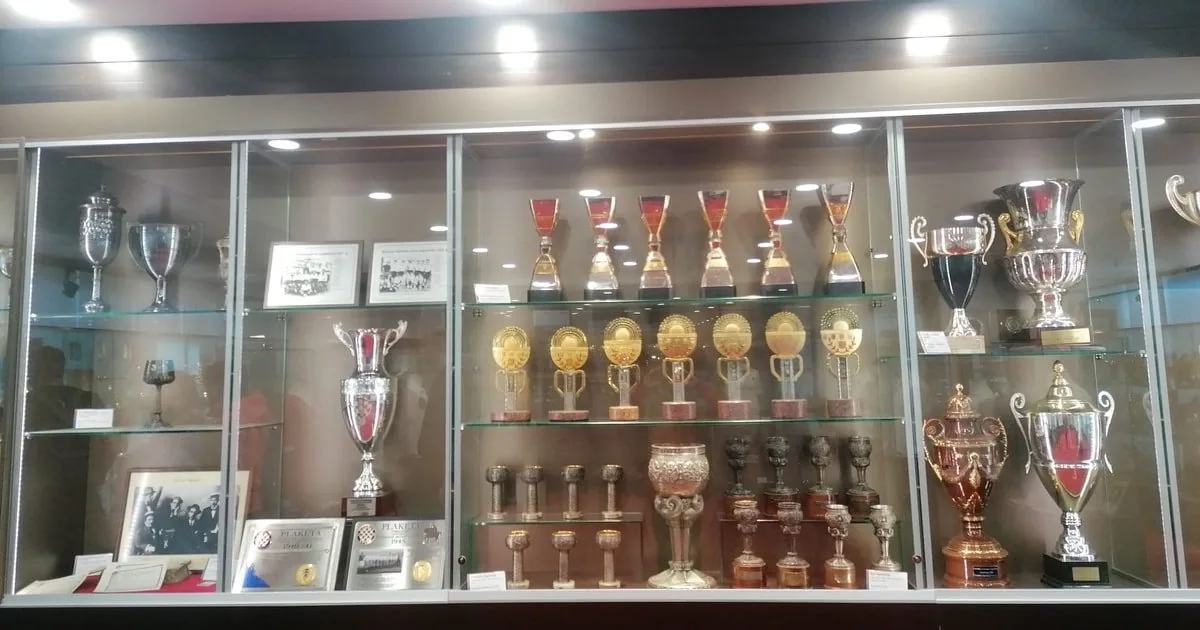 Ein Pokalschrank mit einem großen silbernen Pokal und Reihen kleinerer Trophäen