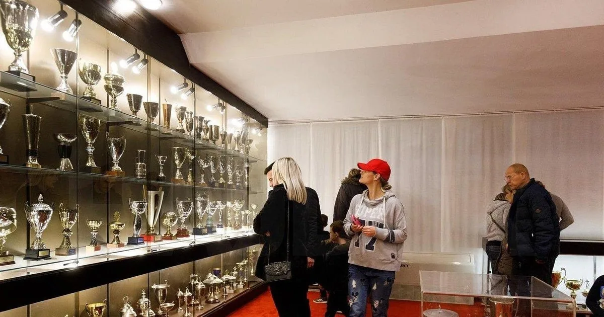Visitantes observando trofeos de plata tras un cristal en la sala de trofeos del Hajduk